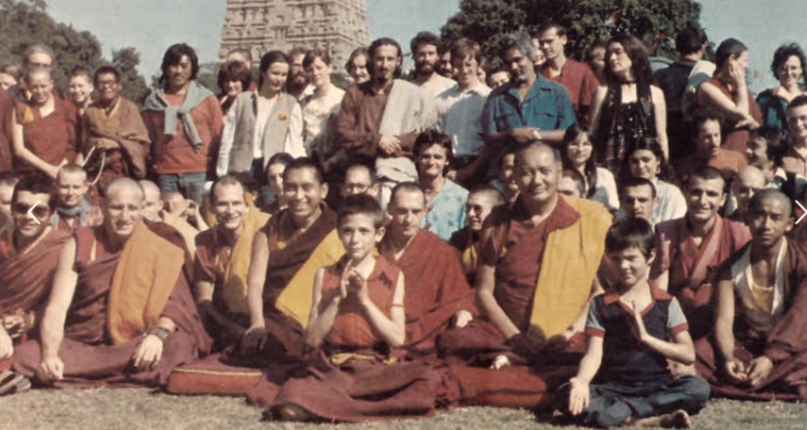 Fotografía histórica de un grupo de practicantes y lamas de la tradición tibetana reunidos ante una estupa